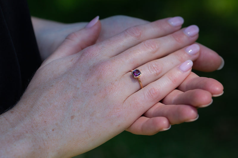 Art Deco Bezel Solitaire Neon Purple Sapphire Ring on engagement ring finger