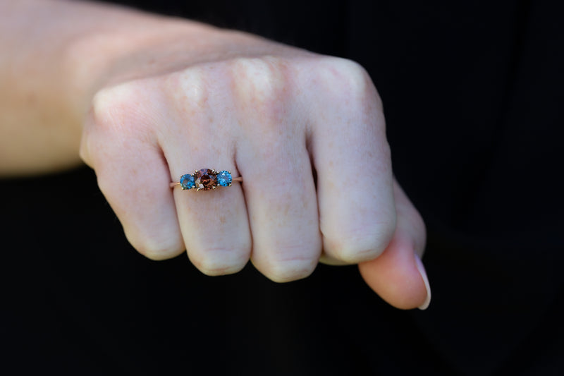 Orange & Blue-Green Teal Sapphires Ring on fist