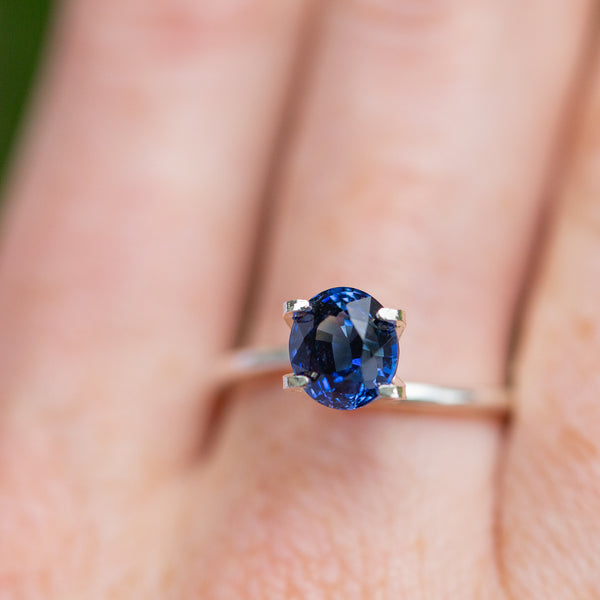 Royal blue sapphire on a finger