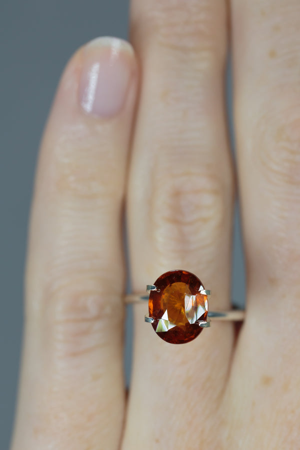 4Ct Deep Orange Brown Hessonite "Cinnamon" Garnet | Oval Shape on ring finger