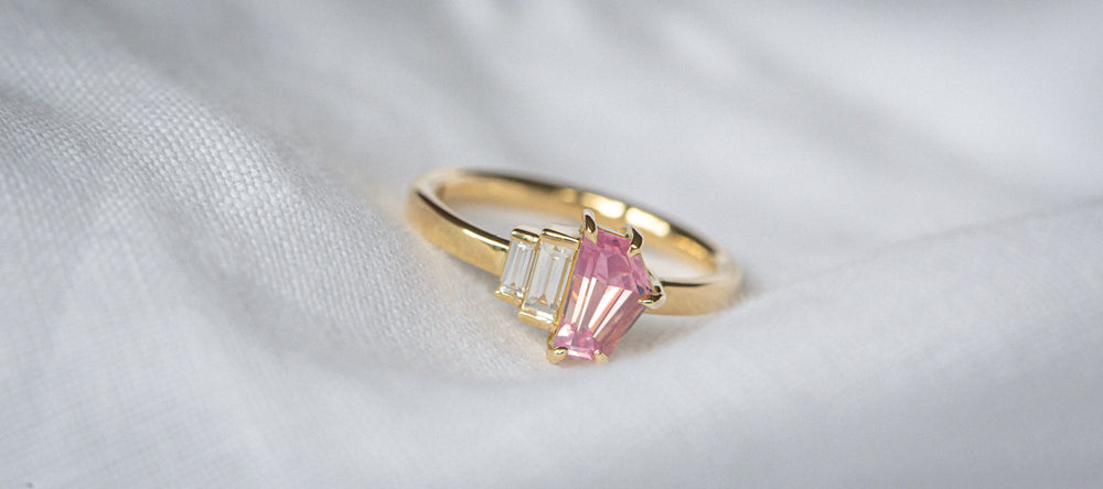 Art Deco inspired Natural Freeform cut Pink Sapphire & Baguette Diamonds ring on a white background 