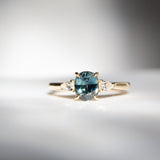 Daintree | 'Four Seasons' | Madagascan Teal Sapphire & Pear Diamonds Trilogy Ring made with 18K yellow gold in sunlight front view 3