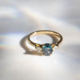 Daintree | 'Four Seasons' | Madagascan Teal Sapphire & Pear Diamonds Trilogy Ring made with 18K yellow gold in sunlight topdown view 2