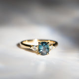 Daintree | 'Four Seasons' | Madagascan Teal Sapphire & Pear Diamonds Trilogy Ring made with 18K yellow gold in sunlight 