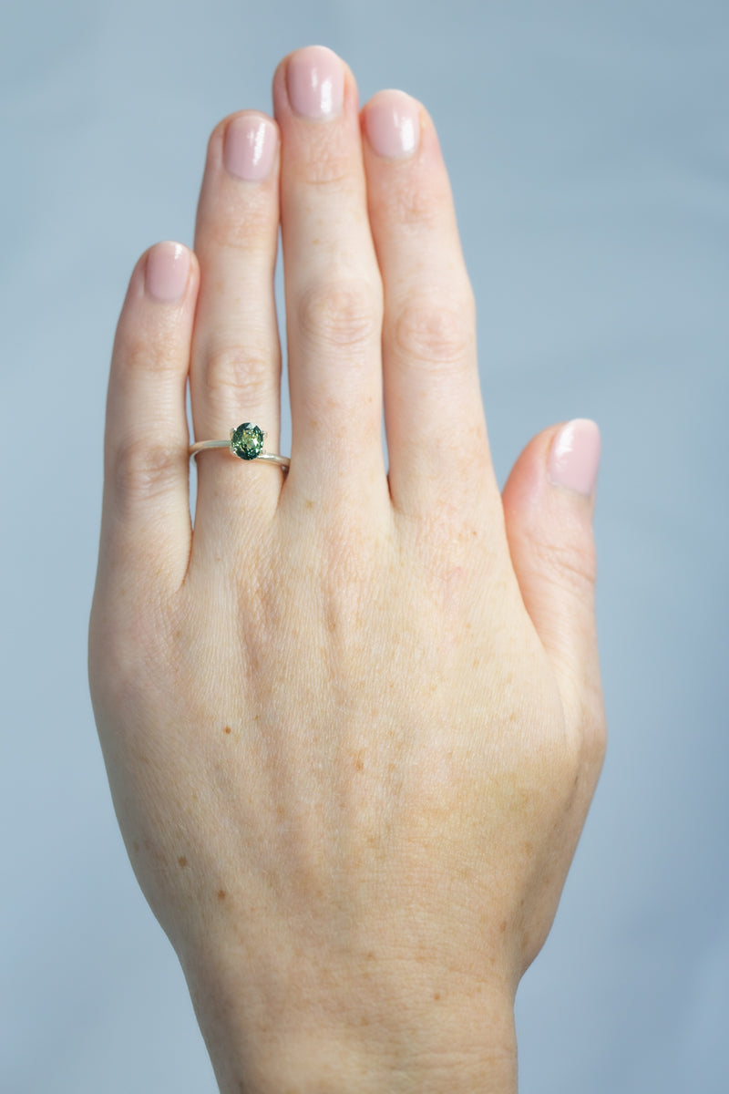 1.25Ct Light-Medium Blue Green Madagascan Sapphire | Oval Shape on hand
