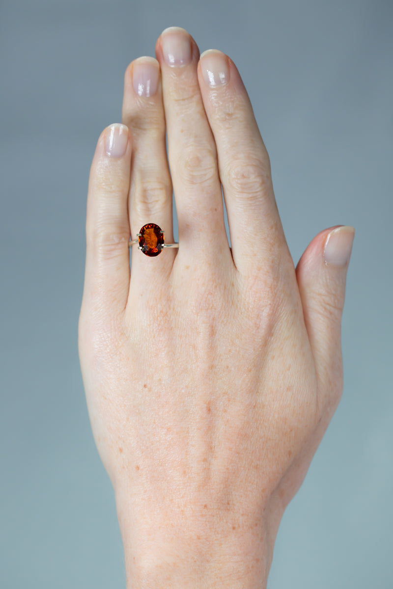 4.3Ct Deep Orange Brown Hessonite Garnet | Oval Shape on hand