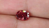 Video of Beautiful 1.52Ct Reddish Orange Sunset Padparadscha Sapphire | Oval Shape from Sri Lanka between fingers